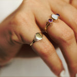 Hand met massief 9 karaat gouden pink signet ring met bewerking op schouders