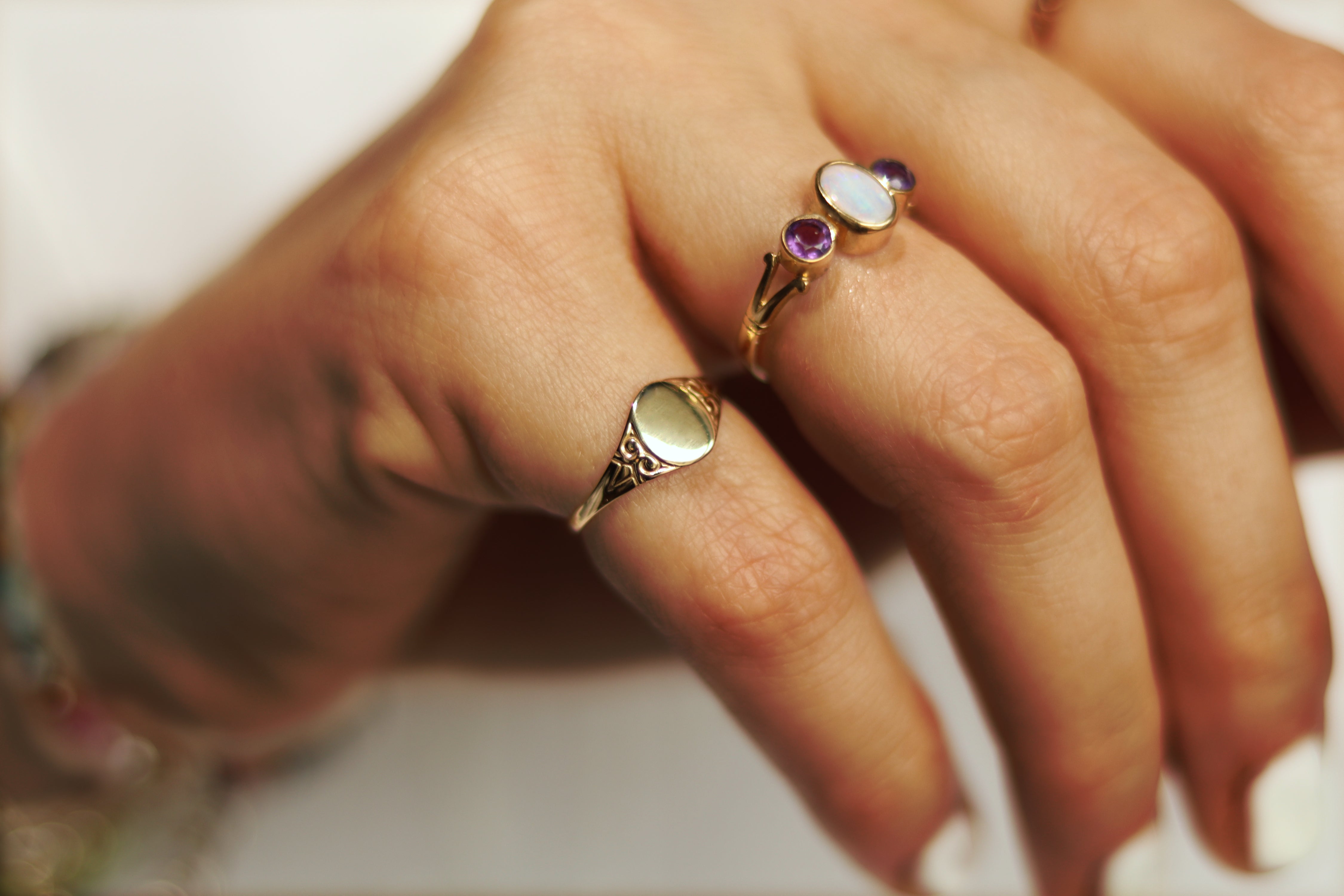 Hand met massief 9 karaat gouden pink signet ring met bewerking op schouders